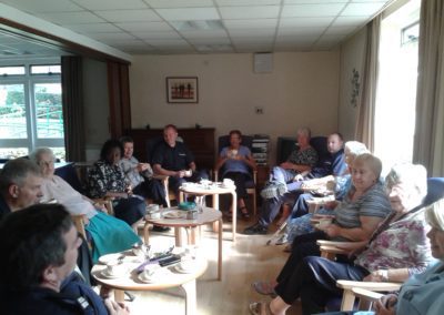 People sitting in a lounge listening to a fire safety talk at Carrs Lane Gardens